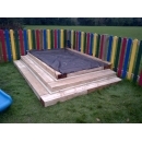 raised wooden sandpit with cover on